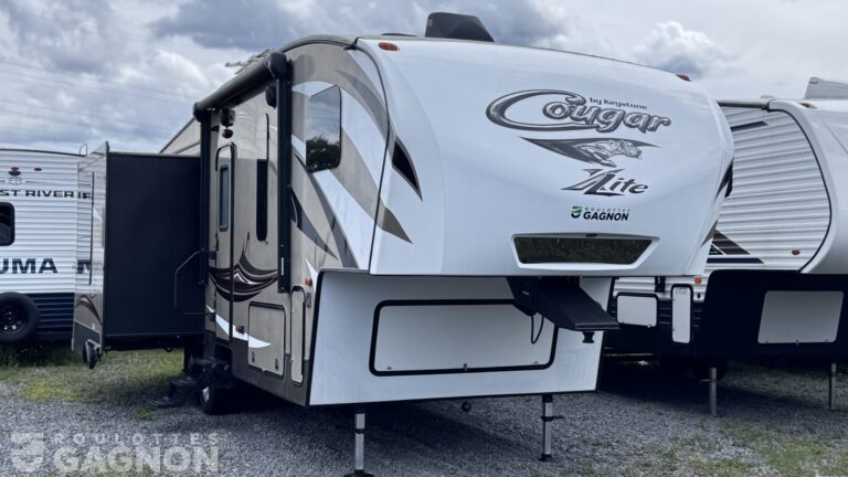 Roulotte de voyage usagée Cougar 28SGS 2016 avec vaste espace de vie, construction en fibre de verre et intérieur confortable.
