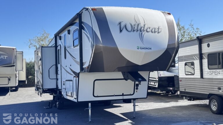 Fifth wheel usagée Wildcat 29RLX 2017 avec trois extensions, salon arrière spacieux et îlot central.